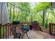 A cozy back deck featuring a small round table and lush green surroundings at 69 Due West Pass, Dallas, GA 30157