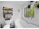 Bathroom featuring a soaking tub with decorative shelves, plants, a window with views, and white paint at 69 Due West Pass, Dallas, GA 30157