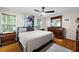 A primary bedroom with hardwood floors, a ceiling fan, modern furnishings, and lots of natural light from the window at 69 Due West Pass, Dallas, GA 30157