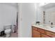 Bright bathroom featuring a toilet, shower with curtain, single sink vanity and large mirror at 8275 Majors Ridge Way, Cumming, GA 30041