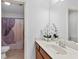 Bright bathroom featuring a toilet, shower with curtain, single sink vanity and large mirror at 8275 Majors Ridge Way, Cumming, GA 30041