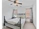 Bedroom features neutral carpet, ceiling fan, and natural light at 8275 Majors Ridge Way, Cumming, GA 30041