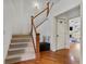 Hallway features a staircase with wood and white trim and a view into the living room at 8275 Majors Ridge Way, Cumming, GA 30041
