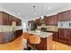 Spacious kitchen with dark wood cabinets, granite countertops, a center island, and stainless steel appliances at 8275 Majors Ridge Way, Cumming, GA 30041