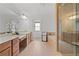 The bright main bathroom features a double sink vanity, soaking tub, and glass enclosed shower at 8275 Majors Ridge Way, Cumming, GA 30041