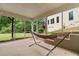 Relaxing screened porch with a hammock overlooking the landscaped backyard and lush green trees at 8275 Majors Ridge Way, Cumming, GA 30041
