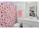 Bright bathroom features a flamingo-themed shower curtain, mirror, and white vanity sink at 1005 Glen Ivy, Marietta, GA 30062