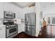 Modern kitchen with stainless steel appliances, white cabinets, and a view of the living area at 1005 Glen Ivy, Marietta, GA 30062