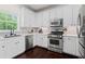 Bright kitchen with white cabinets, stainless steel appliances, and dark hardwood floors at 1005 Glen Ivy, Marietta, GA 30062