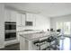 Modern kitchen with a large granite island, stainless appliances, and white cabinetry at 2649 Ogden Trl, Buford, GA 30519