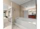 Bathroom with a soaking tub and mirrored wall that reflects vanity with dark wood cabinets at 2865 Lenox Ne Rd # 504, Atlanta, GA 30324
