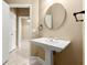 Bathroom features a pedestal sink, an oval mirror, and white trim around the doorway at 2865 Lenox Ne Rd # 504, Atlanta, GA 30324