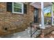 Brick front entrance with black iron railing leading up to a covered porch, offering curb appeal and charm at 6700 Roswell Rd # 19F, Atlanta, GA 30328