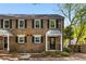 Charming brick townhome featuring classic shutters and a well-maintained front yard with stone and mulch at 6700 Roswell Rd # 19F, Atlanta, GA 30328