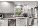 Bright kitchen with white cabinets, stainless steel appliances, and a window overlooking the backyard, perfect for cooking at 6700 Roswell Rd # 19F, Atlanta, GA 30328