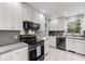 Modern kitchen with white cabinets, stainless steel appliances, and tile flooring, ideal for culinary enthusiasts at 6700 Roswell Rd # 19F, Atlanta, GA 30328
