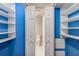 Walk-in closet features custom shelving and blue accent walls leading to the commode at 6700 Roswell Rd # 19F, Atlanta, GA 30328