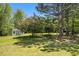 Secluded backyard featuring a shed surrounded by mature trees, offering privacy and ample shade at 1076 Field View Dr, Mcdonough, GA 30253