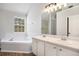 This bathroom features a soaking tub, double sinks, and a large mirror above the vanity at 1076 Field View Dr, Mcdonough, GA 30253