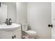 This bathroom features a modern dark faucet, a white sink and vanity, and a white toilet at 1076 Field View Dr, Mcdonough, GA 30253