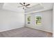 A bedroom with a tray ceiling, ceiling fan, and two windows at 1076 Field View Dr, Mcdonough, GA 30253