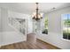 Bright dining room featuring modern flooring, wainscoting, a chandelier, and a white staircase at 1076 Field View Dr, Mcdonough, GA 30253