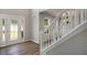 Inviting foyer featuring modern flooring, a decorative glass door, and a white staircase at 1076 Field View Dr, Mcdonough, GA 30253
