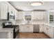 Bright kitchen featuring white cabinets, stainless steel appliances, and wood-look flooring at 1076 Field View Dr, Mcdonough, GA 30253