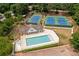Aerial view of a community pool and tennis courts surrounded by lush greenery and well-maintained grounds at 1315 Woodland Trce, Cumming, GA 30041