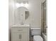 Bathroom with updated vanity, a round mirror, and a glass-enclosed shower/tub at 1315 Woodland Trce, Cumming, GA 30041