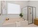 Bathroom featuring a large soaking tub, glass-enclosed shower, and bright natural light at 1315 Woodland Trce, Cumming, GA 30041