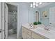 Bathroom featuring double sinks, a large mirror, and a door leading to a separate shower at 1315 Woodland Trce, Cumming, GA 30041