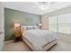 A bedroom featuring a cozy bed, window view, and light green accent wall at 1315 Woodland Trce, Cumming, GA 30041
