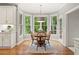 Cozy dining area with bay window offering lush views, wood table set, and hardwood floors at 1315 Woodland Trce, Cumming, GA 30041