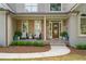 Inviting front porch with stone accents, stylish seating, manicured shrubs and a decorative door wreath at 1315 Woodland Trce, Cumming, GA 30041