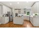 A gourmet kitchen featuring white cabinets, stainless steel appliances, and a spacious island at 1315 Woodland Trce, Cumming, GA 30041