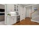 Open kitchen area with beverage cooler, white cabinets, and hardwood flooring at 1315 Woodland Trce, Cumming, GA 30041