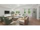 Bright living room featuring hardwood floors, recessed lighting, and large windows providing ample natural light at 1315 Woodland Trce, Cumming, GA 30041