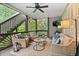 Screened-in porch with comfortable seating, ceiling fan, and view of lush backyard at 1315 Woodland Trce, Cumming, GA 30041