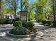 Entrance to the White Oak at East Lake community with landscaped flower bed and mature trees at 1608 Falcon Crest Way # 58, Decatur, GA 30032
