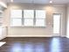 Open-concept living room with three windows, hardwood floors and neutral paint at 1608 Falcon Crest Way # 58, Decatur, GA 30032
