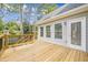 A view of a wood back deck with access to the home through a set of windows and a door at 1611 Threepine Pl, Lilburn, GA 30047