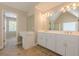 Bright bathroom featuring double vanity sinks, an elegant vanity and a doorway leading to another room at 1611 Threepine Pl, Lilburn, GA 30047