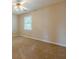 Neutral bedroom with window allowing natural light and ceiling fan with decorative light fixture at 1611 Threepine Pl, Lilburn, GA 30047