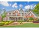 Charming two-story brick home featuring a welcoming front porch and beautifully landscaped front yard at 1611 Threepine Pl, Lilburn, GA 30047