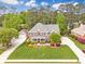 Beautiful two-story brick home with a lush green lawn, mature trees, and a long driveway at 1611 Threepine Pl, Lilburn, GA 30047