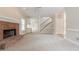 Spacious living room features a brick fireplace, neutral carpet, and a staircase leading to the second floor at 1611 Threepine Pl, Lilburn, GA 30047
