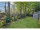 Backyard with a lush green lawn, mature landscaping, and a staircase leading to an upper-level deck at 2473 Kings Arms Dr, Atlanta, GA 30345