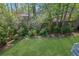 Lush backyard featuring a well-manicured lawn, vibrant garden beds, and mature trees for added privacy and natural beauty at 2473 Kings Arms Dr, Atlanta, GA 30345