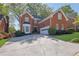 Charming two-story brick home featuring an attached two-car garage and lush landscaping at 2473 Kings Arms Dr, Atlanta, GA 30345